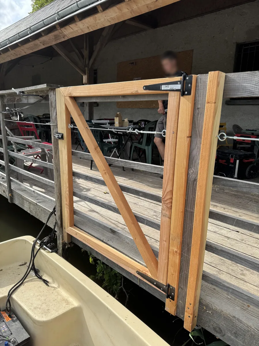 Portillon en bois neuf posé à l'entrée d'un ponton, au-dessus de l'eau