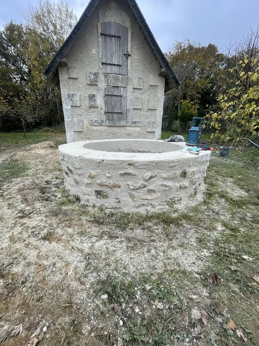Vasque circulaire en pierre achevée et remplie de terre, avant la plantation de l'arbre